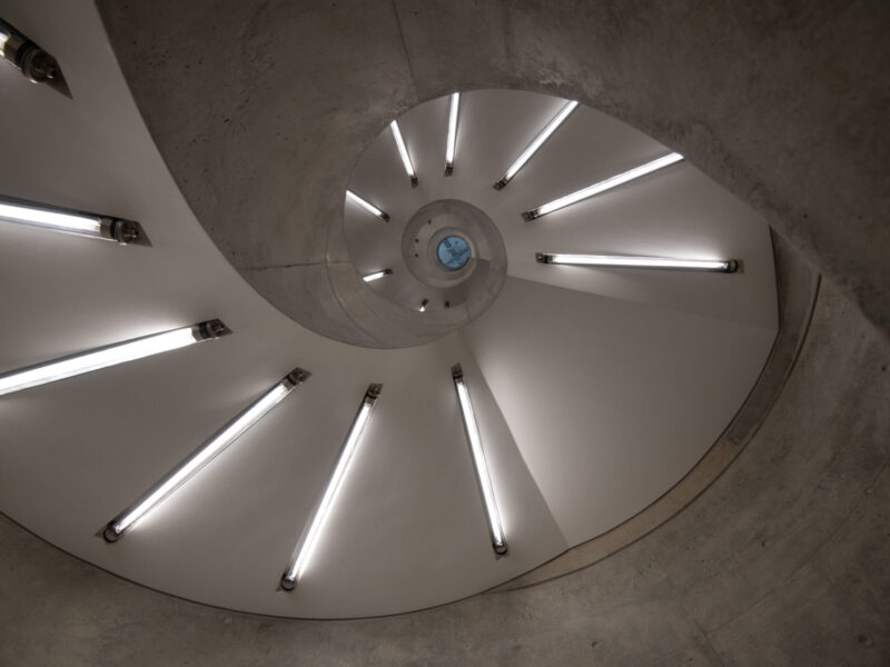 Modern spiral staircase glowing with fluorescent tube lighting
